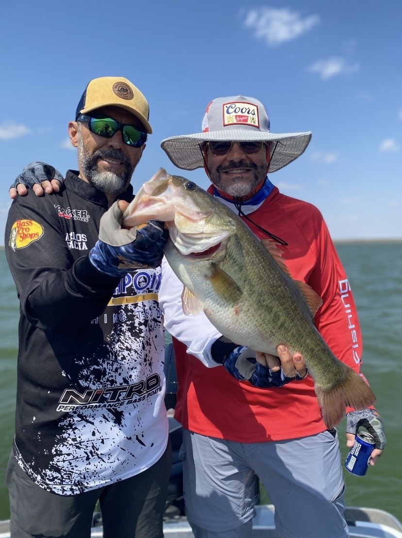 Two anglers with big bass on sunny day