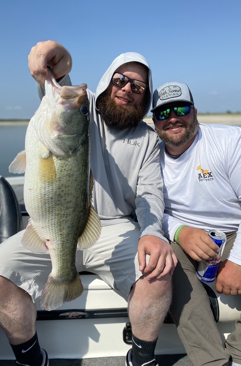 Two men with large bass on sunny day