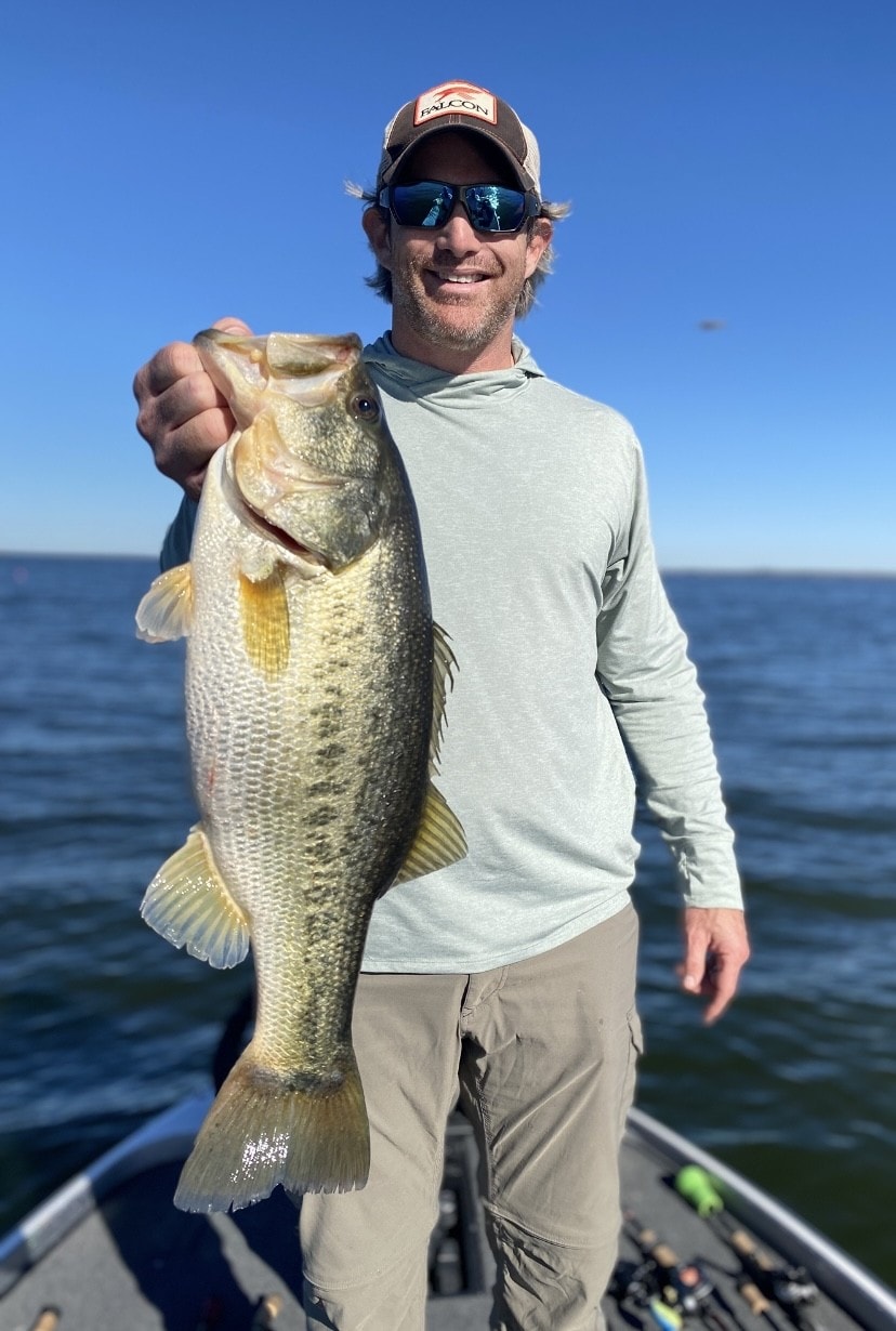 Angler in Falcon cap with trophy largemouth bass