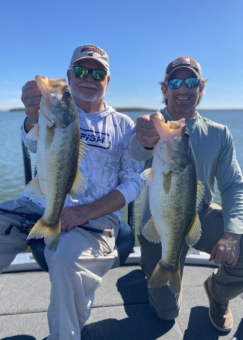 Two anglers holding bass on Lake Falcon