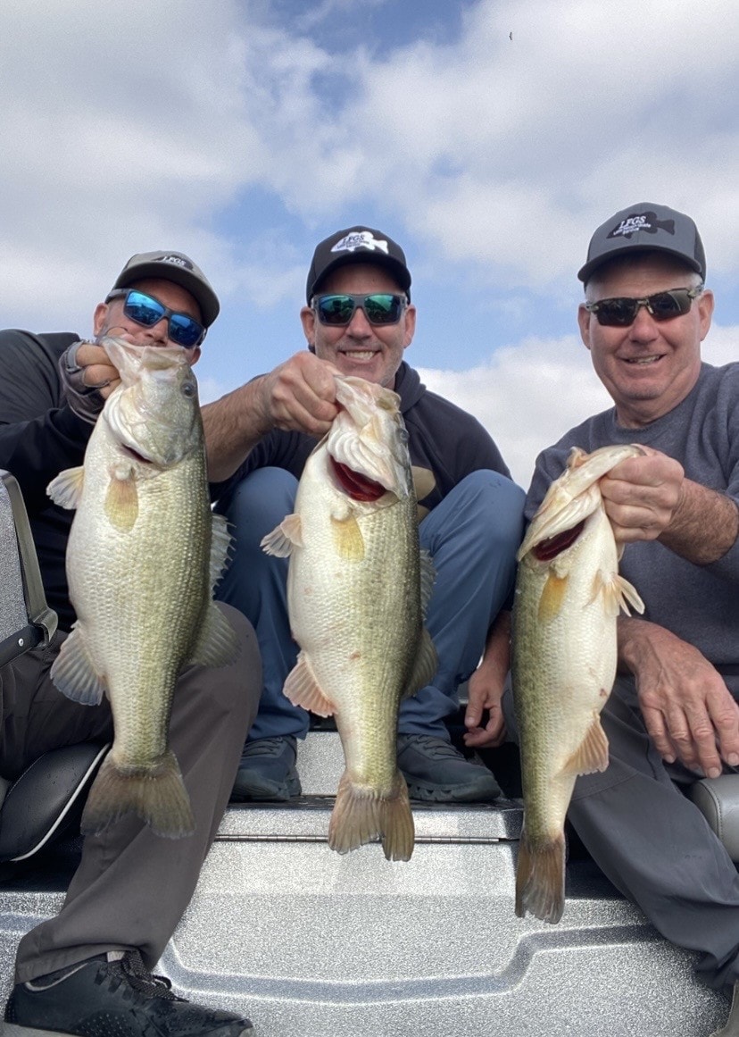 Three anglers with big bass in LFGS caps