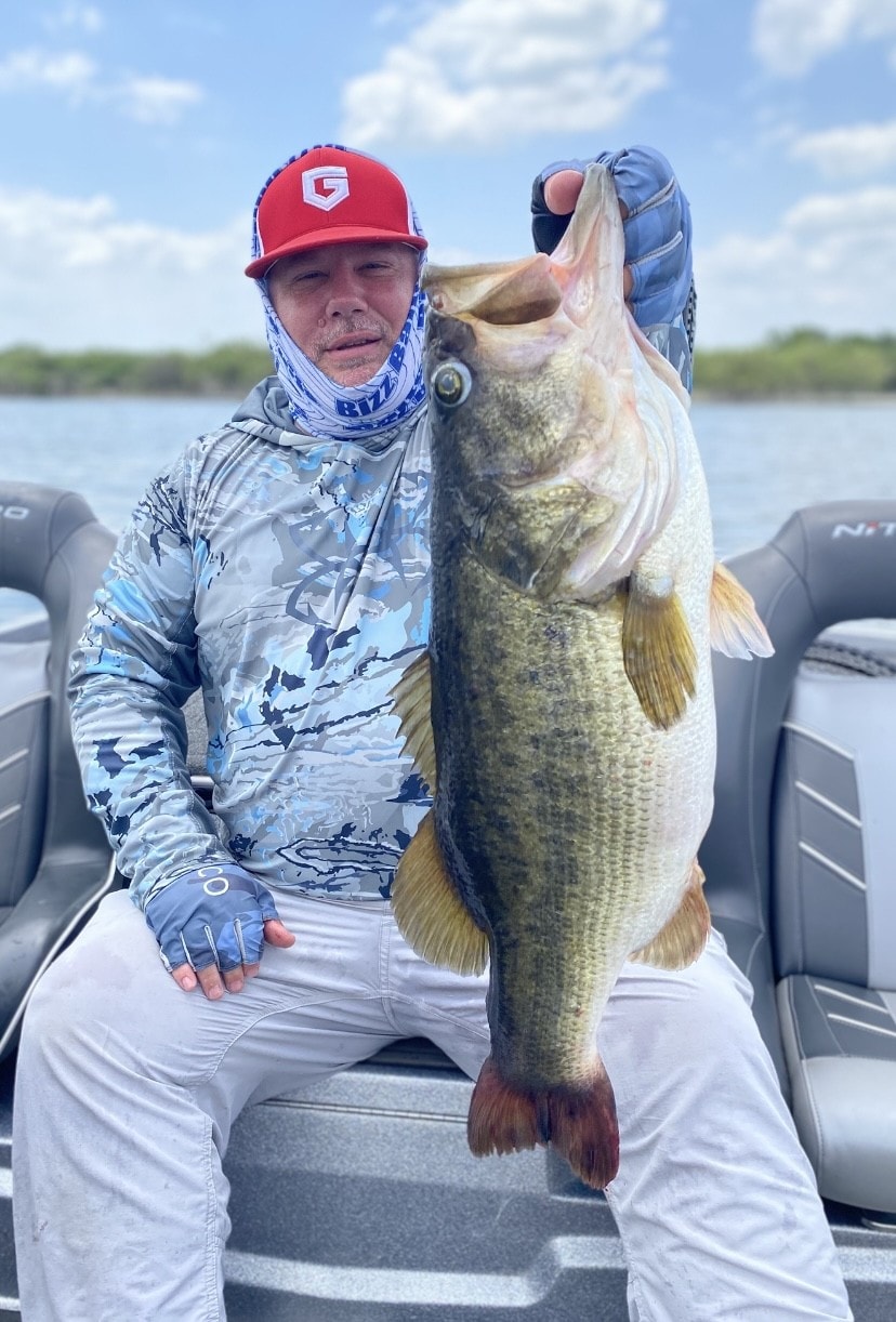 Angler in red cap holding giant bass