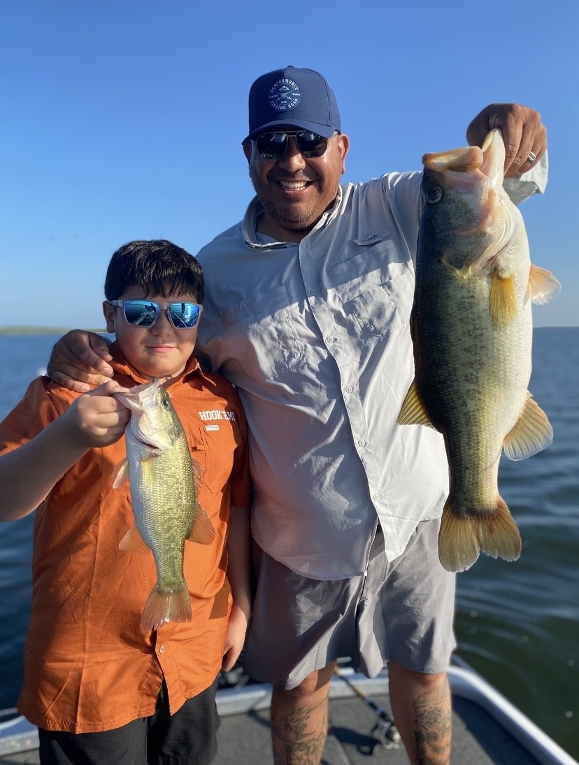 Father and son each holding a bass