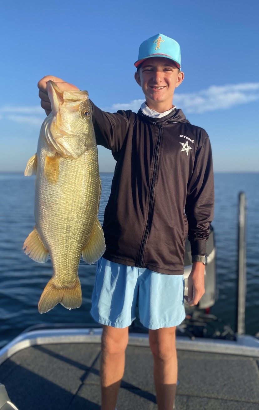 Teen in blue Stars hoodie holding golden bass