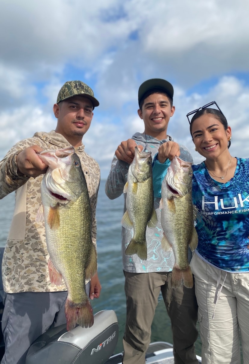 Three anglers on Nitro boat each holding bass