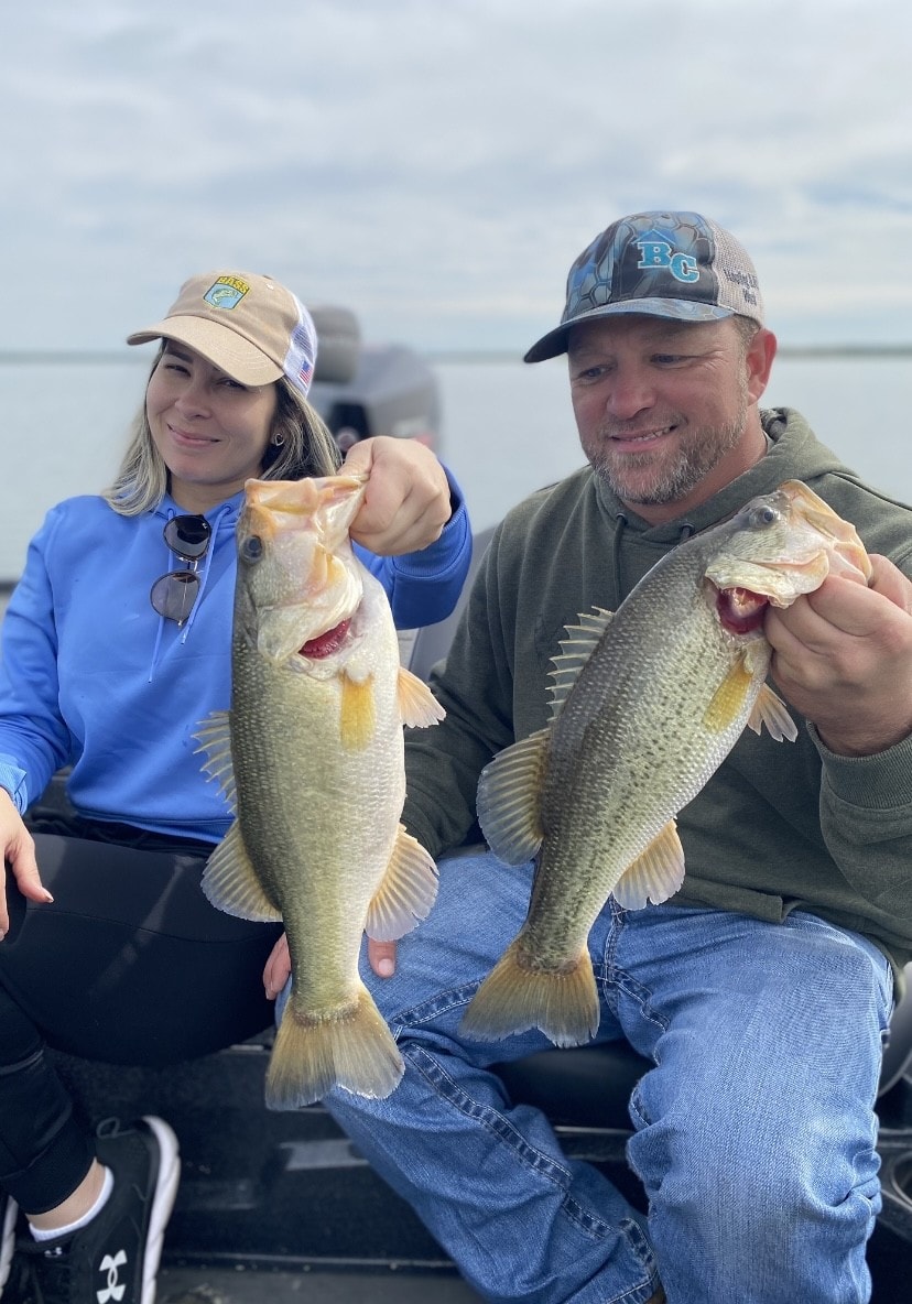 Two anglers each holding bass on cloudy day on Lake Falcon