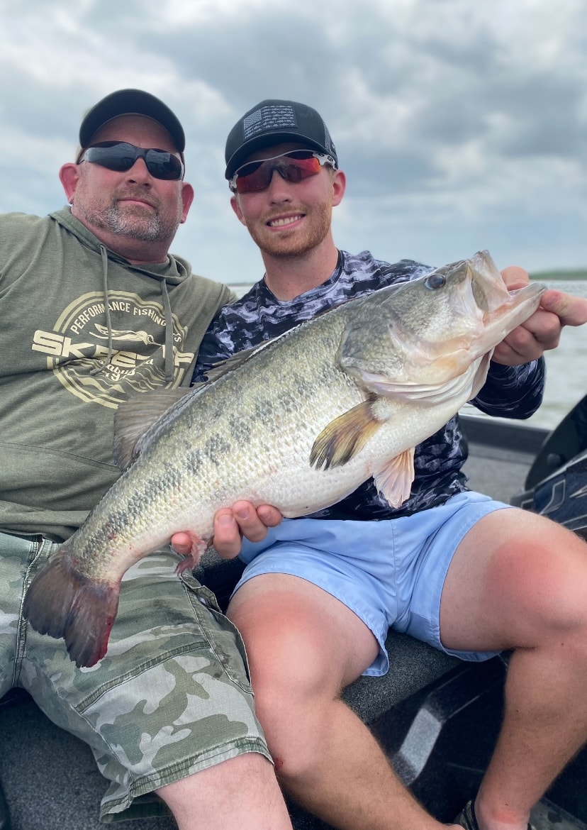 Father and son with massive trophy bass on cloudy day